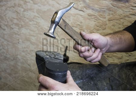 Shoe repair. Shoemaker is repairing shoe. Hands taken closeup. Concept of man job. shoemaker holding hammer.