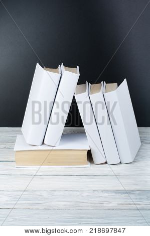 Open black and Whitel books on wooden table, black board background. Back to school. Education business concept
