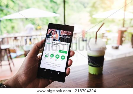 Chiang Maithailand - Nov 13 2017 :man Hand Holding Grab App Showing On Sony Experia With Computer La