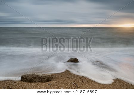 Beautiful Vibrant Sunset Landscape Image Of Burton Bradstock Golden Cliffs In Dorest England