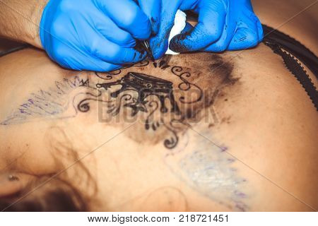 Russia, Novokuzneck, 5.07.2017: tattooer showing process of making a tattoo hands holding a tatoo machine