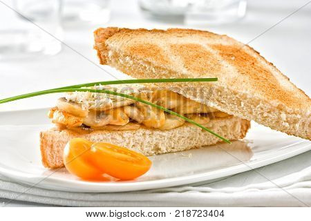 Chicken sandwich served with mushrooms and cheese.