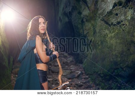 Shot of a mature Amazon fighter smiling looking away standing in the woods with a bow in her hands smiling joyfully copyspace femininity confidence safety potection weapon security.