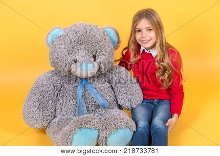 Girl Hug Big Teddy Bear On Orange Background