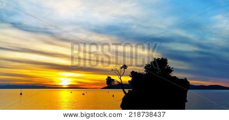 Dramatic sunset over the Adriatic Sea with Kamen Brela - Tiny famous island in Brela, Makarska Riviera, Croatia