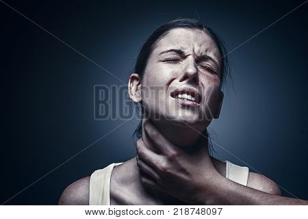 Home violence - young woman is choked by man's hand. The concept of protection from violence