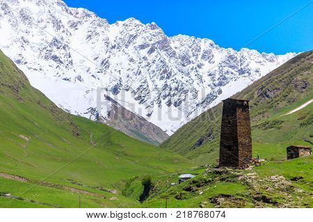 View of the Ushguli village at the foot of Mt. Shkhara. Picturesque and gorgeous scene. Rock tower in Ushguli - the highest inhabited village in Europe