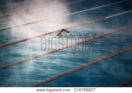Swimming in the pool and morning fog over the water