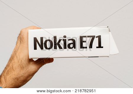 PARIS FRANCE - DEC 18 2017: Man holding against white background vintage and luxury NOKIA box of a E71 smartphone with specification technical details