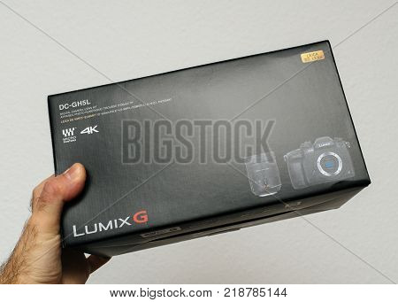 PARIS FRANCE - DEC 18 2017: Man holding Panasonic Lumix GH5 kit with Leica lens cardboard box received by post
