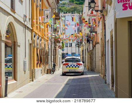 Tossa de Mar, Spain - June 25, 2013: Spanish local police car moving on narrow street of old town.
