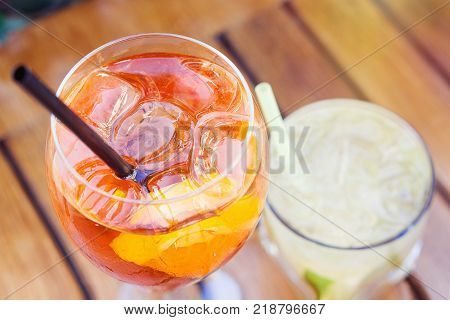 Spritz and caipirinha coctails two glasses on the summer terrace of a cafe; selective focus