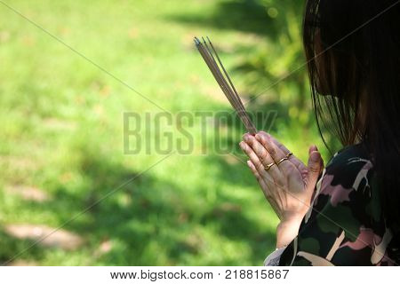 Asian people pay respect to shrine of the household god or spirit worship Incense and firecrackers