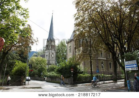 Travelers people walking and biking bicycle at junction road near Chiesa evangelica di Cristo church at Meran city on September 2 2017 in Merano Italy