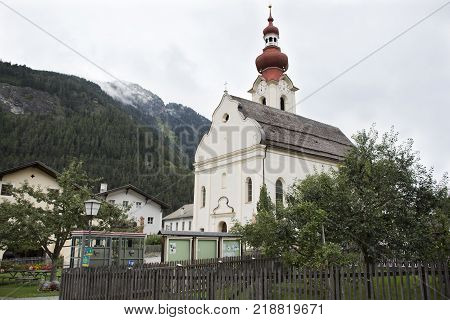 Travelers people travel and visit Kath. Pfarramt church and classic building in small alley at Pfunds village in evening time in Tyrol Austria