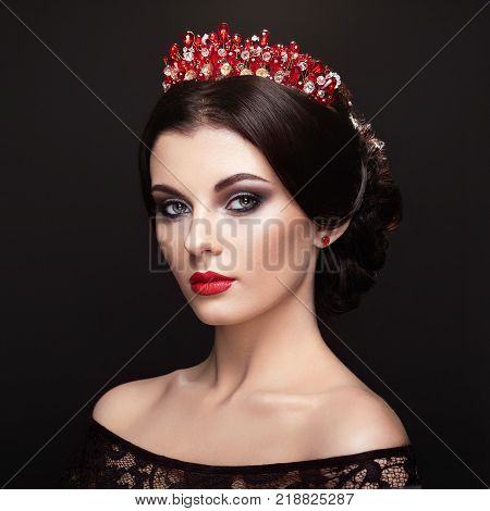 Fashion Portrait of Beautiful Woman with Tiara on head. Elegant Hairstyle. Perfect Make-Up and Jewelry. Red Lips