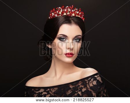 Fashion Portrait of Beautiful Woman with Tiara on head. Elegant Hairstyle. Perfect Make-Up and Jewelry. Red Lips