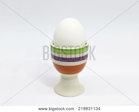 Egg in pastel colours eggcup holder isolated on white background