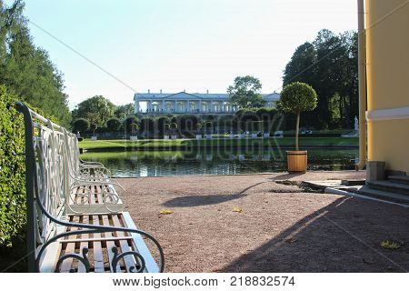 Summer sunny garden with lake and classical bench in the Catherine park, Pushkin, St. Petersburg