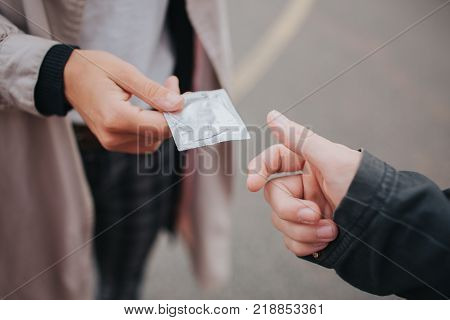 a man passes the condom to the woman