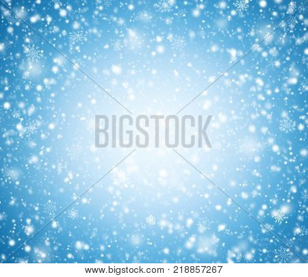 Blue winter background with snowflakes and light.