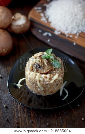 Italian mushroom risotto on black ceramic plate over table