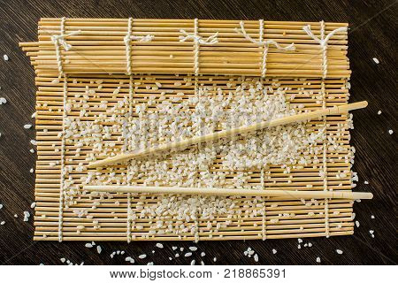 sushi-rug chopsticks and rice lie on the table