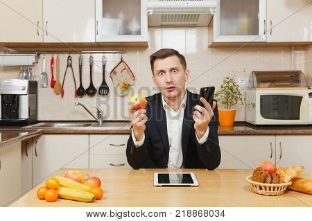 Perturbed Young Business Man In Suit, Shirt, Having Breakfast, Sitting At Table With Tablet, Spreadi