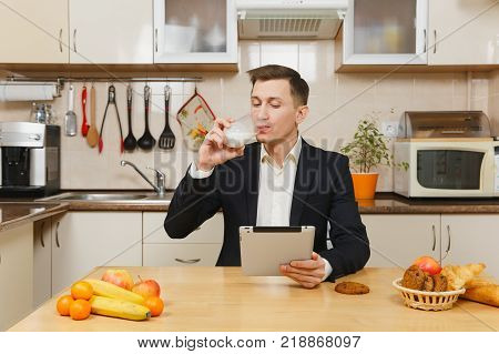 Perturbed Young Business Man In Suit, Shirt, Having Breakfast, Sitting At Table With Tablet, Spreadi