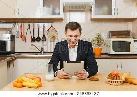 Perturbed Young Business Man In Suit, Shirt, Having Breakfast, Sitting At Table With Tablet, Spreadi