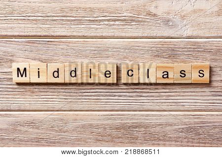 Middle class word written on wood block. Middle class text on table concept.