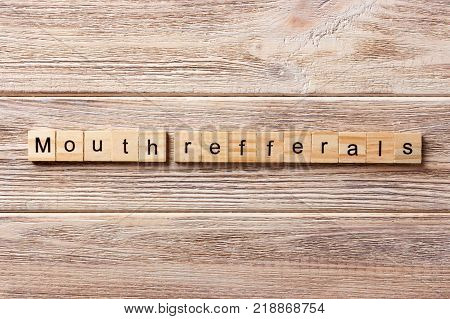 mouth refferals word written on wood block. mouth refferals text on table concept.