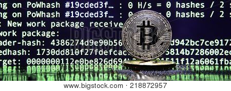 The digital process of cryptocurrency mining by using the GPUs. Bitcoins and video card on a working display and mining screen
