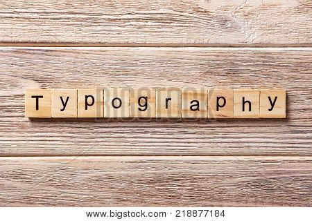 typography word written on wood block. typography text on table concept.