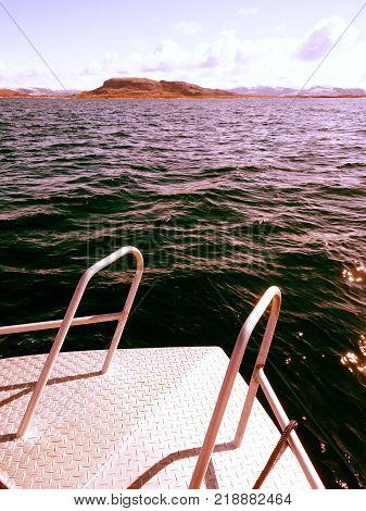 Fishing boat with fishing rods floating in open sea. Background beautiful sky. Sport sea fishing