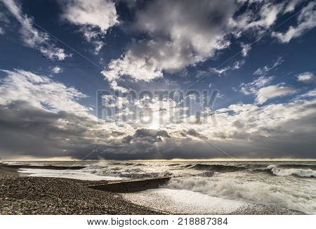 deserted stone beach in stormy weather at sunset