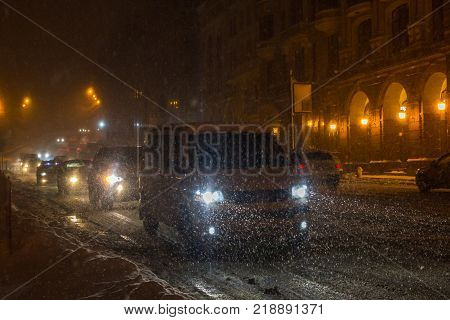 Street with traffic at blizzard evening. Winter, snow city car. Kiev, Ukraine