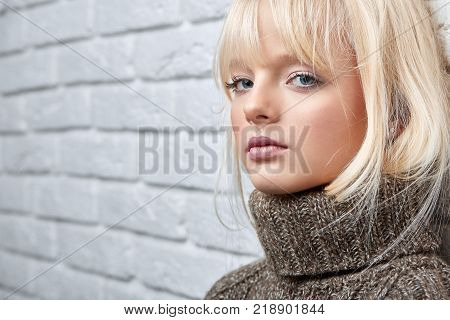 Cropped close up shot of an attractive young woman in a warm woolen sweater looking to the camera copyspace home seasonal winter coziness relaxation weekend enjoyment.