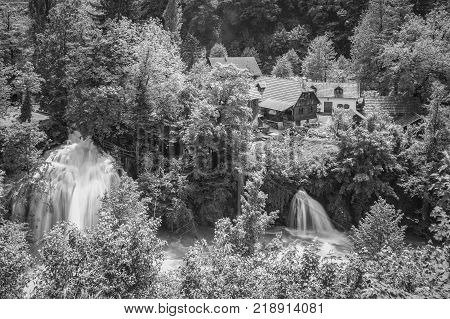 Croatian Village Of Rastoke By A River Canyon With Wooden Houses In A Green Landscape With Trees And