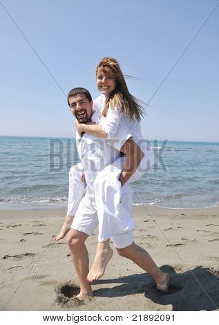 Szczęśliwa młoda para miłej zabawy i romantyczne chwile na plaży w sezonie letnim i reprezentujących happynes