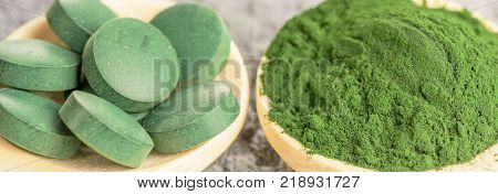 Chlorella spirulina green algae in powder and tablets form- closeup macro shot