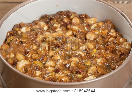 Panforte Preparation, Cooking Process. Raw Mix Of Nuts, Figs, Spices In Baking Tray. Rice Paper