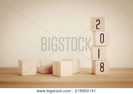 2018 new year greeting card with copy spce for text wooden cubes with 2018 on wooden table background new year template vintage filtered