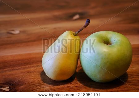 Fresh pear and apple on wooden table