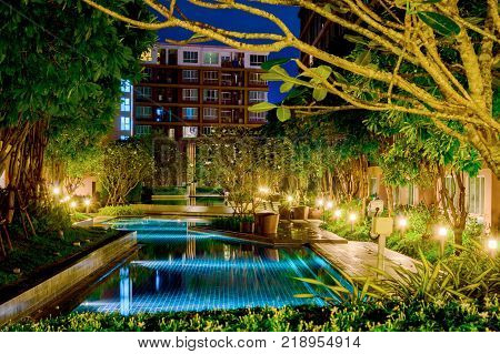 Courtyard of an apartment house with shallow blue pool.