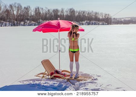 Novokuznetsk, Kemerovo region, Russia - 23 Feb, 2017 : White beaches of Siberia is an enterteiment activity where people playing beach games dressed in bikini in winter. Woman in bikini with pineapple