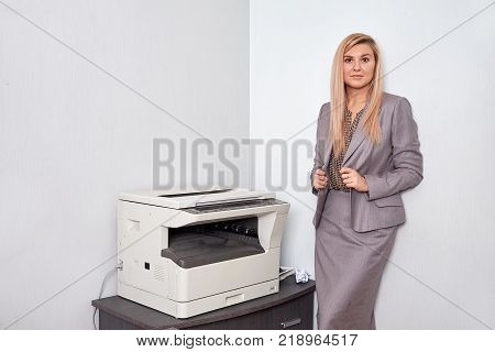 Businesswoman working on a copy machine at the office.