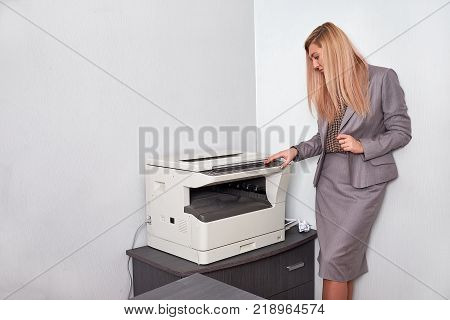 Businesswoman working on a copy machine at the office.