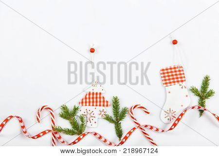 Christmas holiday composition. Festive creative red pattern, xmas handmade decor holiday with ribbon, candy canes, gift, christmas tree and decorations on white background. Flat lay, top view