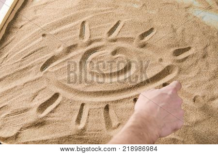a man draws by his finger on the sand symbol of eye